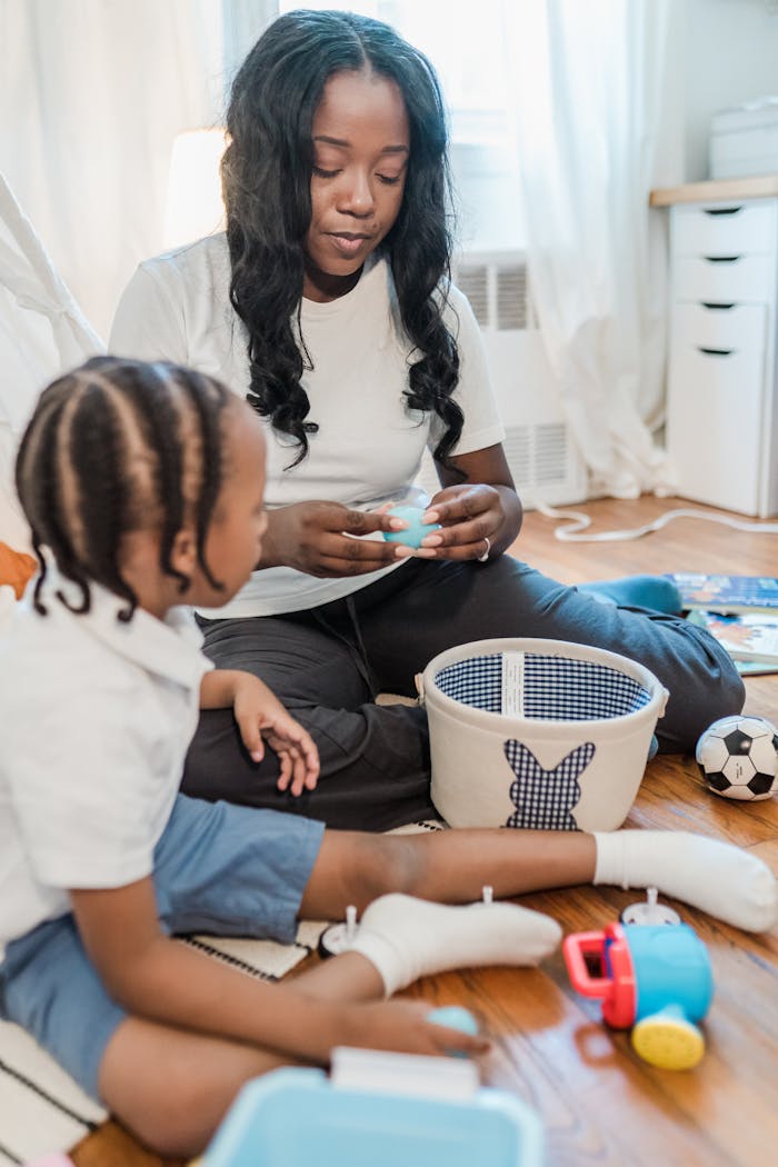 A mother and her young son play with toys together in a warm, cozy indoor setting.